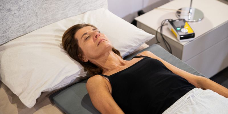 Persona mayor sobre colchoneta de magnetoterapia Osteomat en la cama