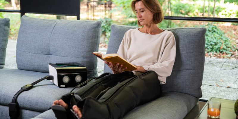 Mujer con equipo de presoterapia domiciliaria i-Press en las 2 piernas